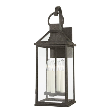 A cottage-style wall sconce with a French Iron finish and clear glass windowpanes, featuring a candlestick light source.